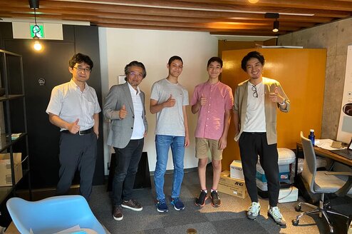 Interns and their coworkers give a thumbs up.